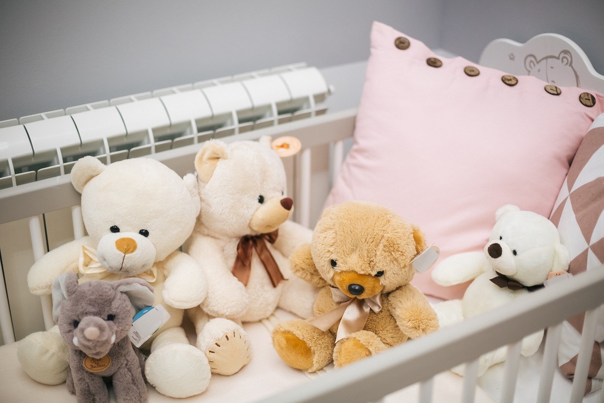 plišani medvedići u krevecu za bebu